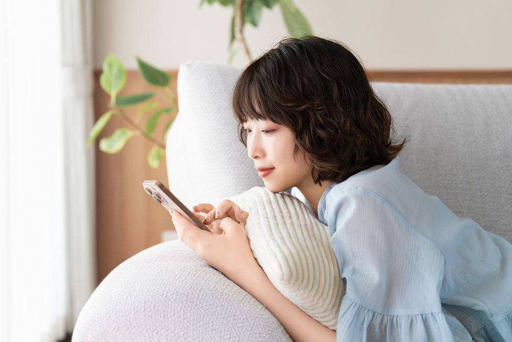 スマートフォンでブログをチェックする女性。すきま時間にアフィリエイト活動ができるイメージ