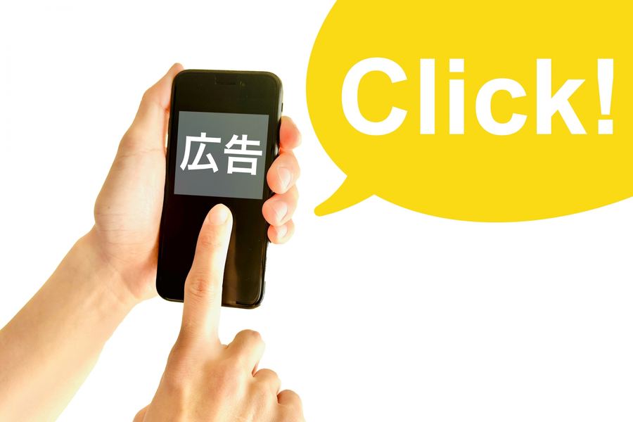 スマートフォンの広告をタップする手。紹介リンクをクリックしてもらうイメージ